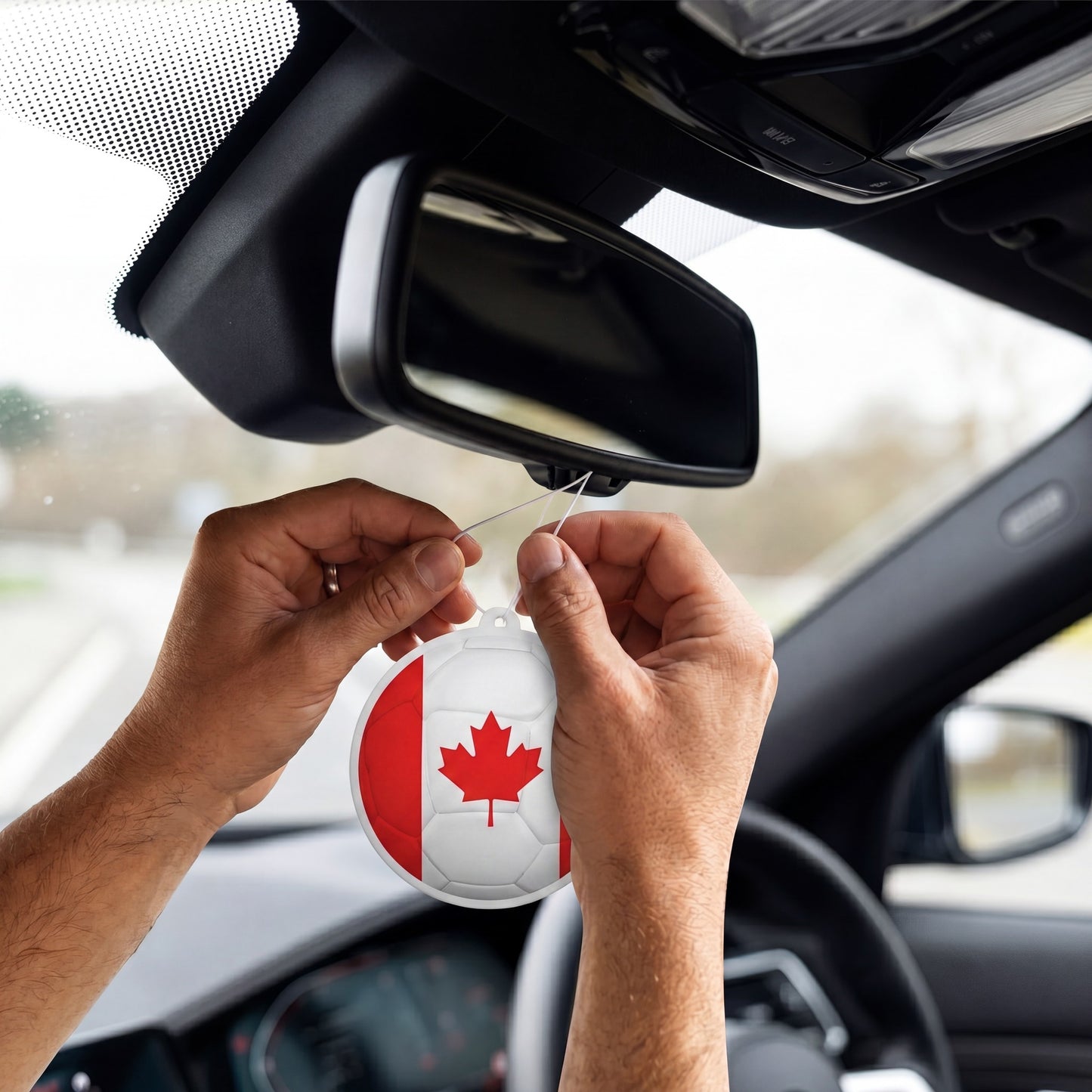 Canada flag car freshener hanging on rearview mirror